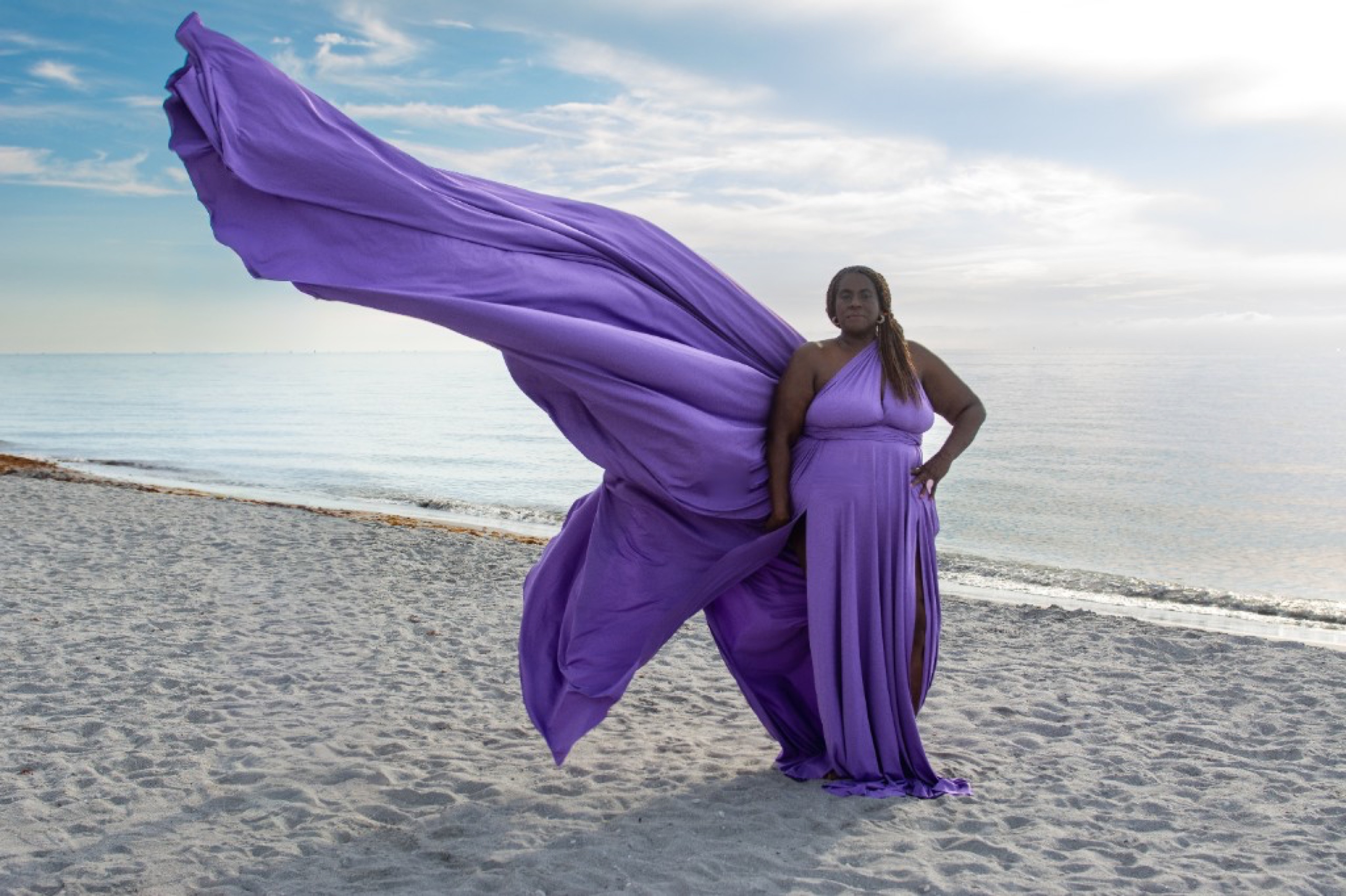 Flying dress photoshoot on the beach — orchid purple gown billowing in the breeze