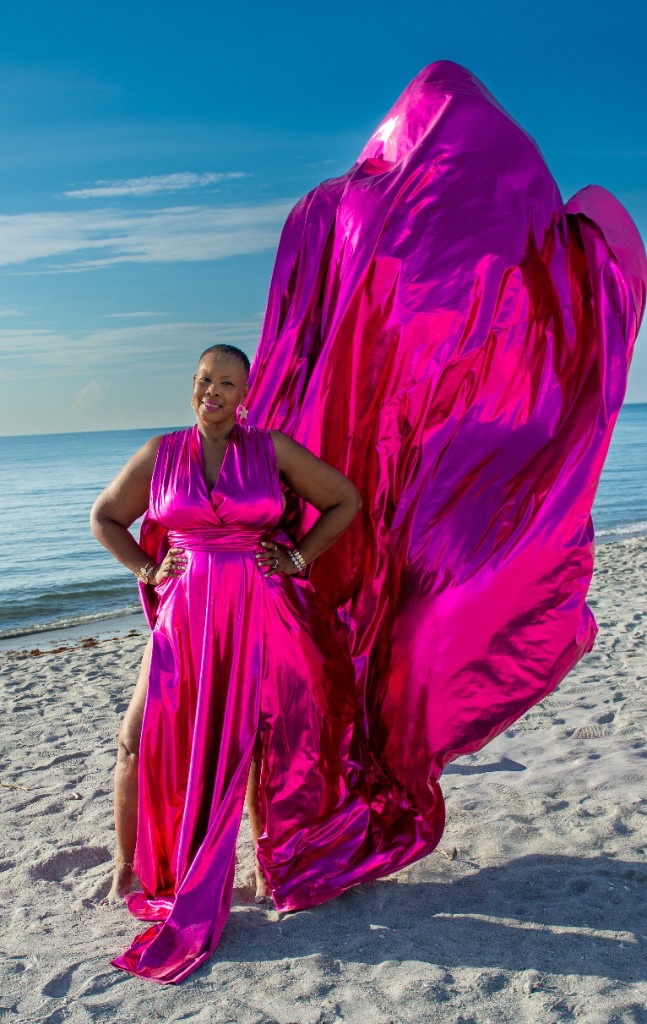 Flying dress photoshoot on the beach — metallic pink gown with train soaring in the wind
